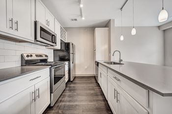 A kitchen with white cabinets and stainless steel appliances.